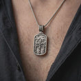 Load image into Gallery viewer, Oxidized Silver Three Crosses Crucifixion pendant worn on a man's chest with an open black shirt, showcasing Jesus between two crucified thieves.
