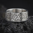 Load image into Gallery viewer, Polished Silver Viking symbol ring on black volcanic rock, highlighting the central interlocking triangle design and symmetrical hemp leaf motifs.
