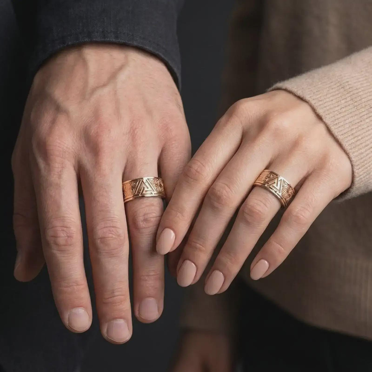 Rose Gold Plated Valknut symbol rings worn by a man and woman together, emphasizing the symmetrical star patterns and bold triangular knot motif.