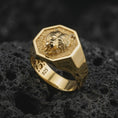 Load image into Gallery viewer, Gold plated 925 sterling silver roaring bear ring displayed on textured black volcanic rock, featuring a raised bear head sculpture, powerful open jaws, detailed fur carvings, bold hexagonal border, and warm gold plated finish.
