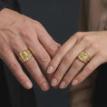 Load image into Gallery viewer, Gold plated 925 sterling silver matching Saint Nicholas Catholic rings worn on the fingers of a man and woman together, featuring raised bishop portraits, detailed mitres, curved croziers, books with three symbolic balls, engraved Christian crosses, and warm gold plated finishes.
