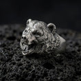 Load image into Gallery viewer, Oxidized 925 sterling silver roaring bear head ring displayed on textured black volcanic rock, featuring a realistic three-dimensional bear face, wide open mouth, exposed sharp fangs, detailed fur, rounded ears, and dark oxidized silver finish.
