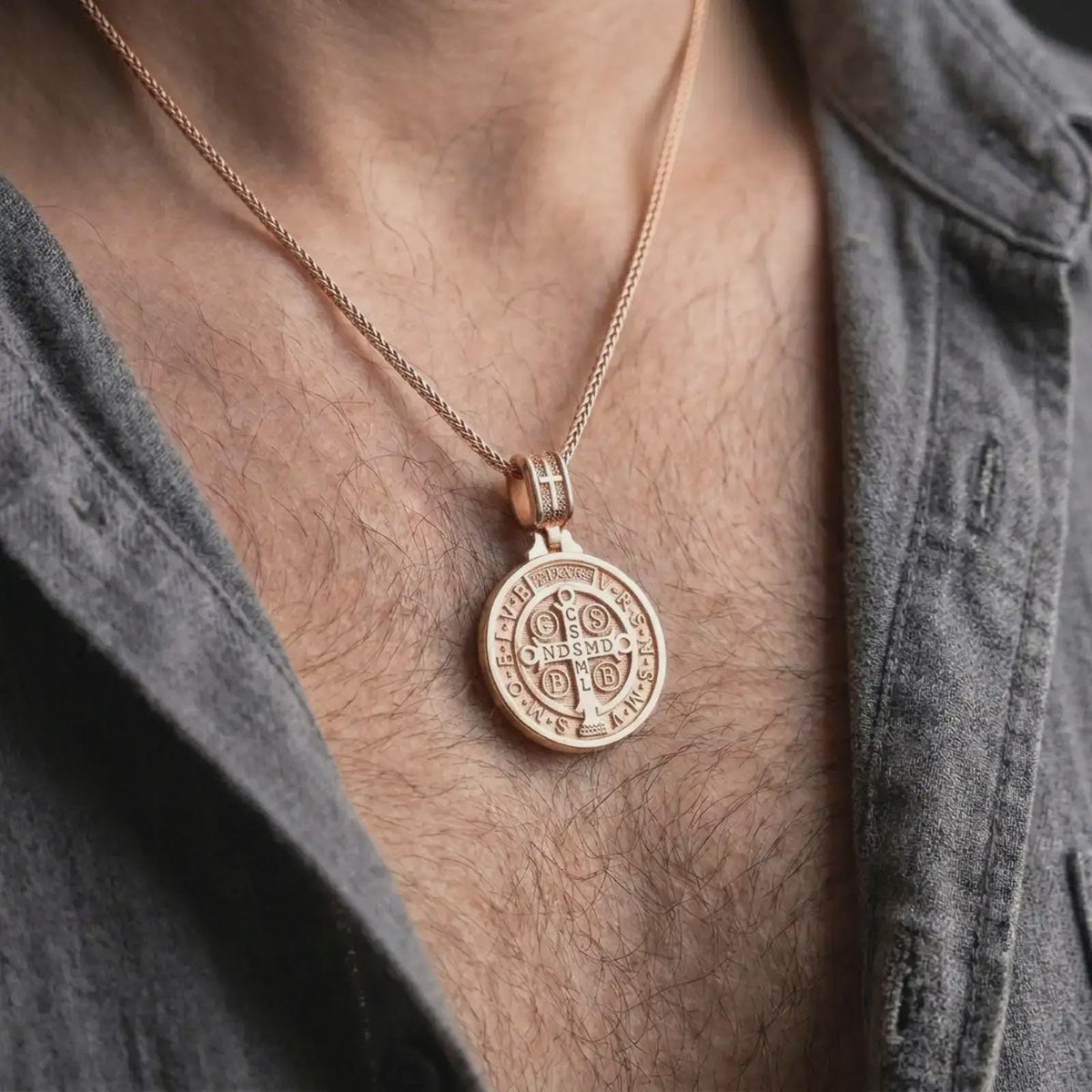 Rose Gold Plated Saint Benedict pendant hanging on a man's chest, showcasing the double sided Catholic necklace design.