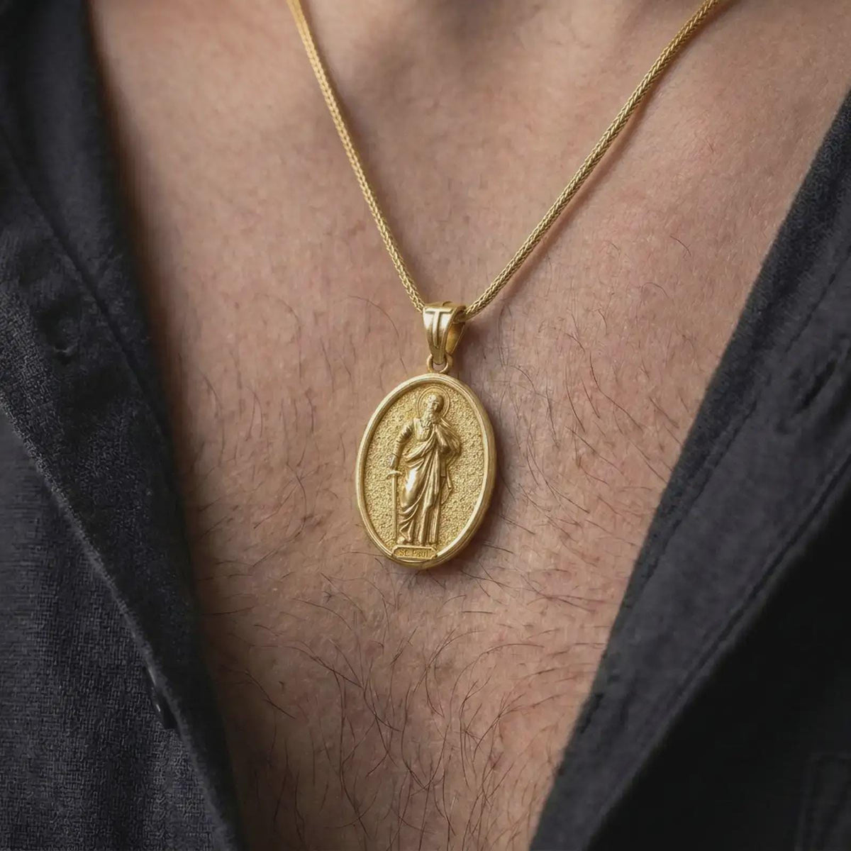 Gold Plated Saint Paul Catholic pendant worn on a man's chest with an open black shirt, displaying the haloed apostle and religious details.