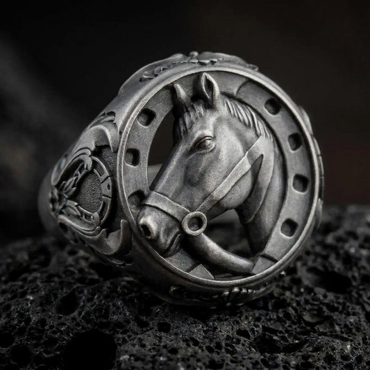 Oxidized Silver Horse Head Horseshoe Ring on black volcanic rock, featuring a realistic 3D horse portrait framed by a detailed horseshoe.