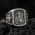 Load image into Gallery viewer, Oxidized Silver Saint Paul Apostle signet ring on black volcanic rock, featuring the haloed saint holding a sword and book in detailed relief.
