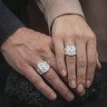 Load image into Gallery viewer, Polished Silver Saint Cecilia signet rings worn by a man and woman together, highlighting the musical instrument, starry halo, and geometric engravings.
