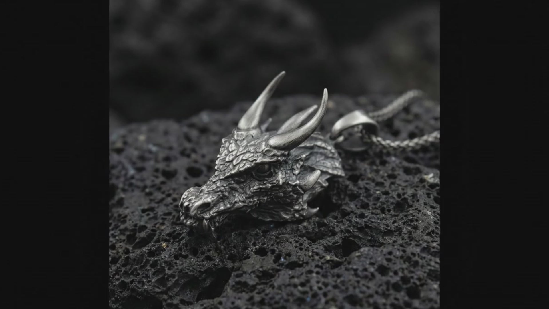 Dragon head pendant necklace on volcanic stone background Detailed dragon head jewelry with sculpted horns and scales Mythical dragon talisman pendant high detail macro shot